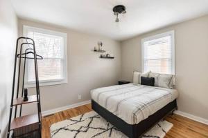 Un dormitorio con una cama y dos ventanas. en Let's Get Cozy In Nashville!, en Nashville