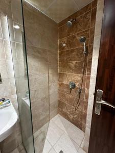 a shower with a glass door next to a sink at Al Khulfaa Al Masy - فندق الخلفاء الماسي in Makkah