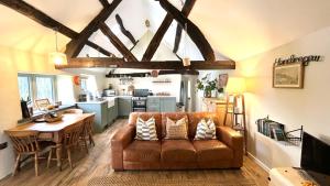 a living room with a brown couch and a table at Peaceful Dyfi Valley Cottage - Hendre-gau in Machynlleth