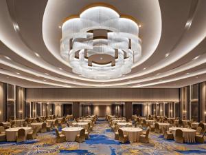 a large banquet hall with tables and a large chandelier at Mercure Padang in Padang +25 photos