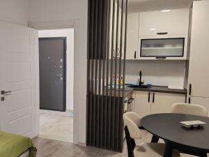 a living room with a table and a kitchen at Lacky-ca in Prokuplje