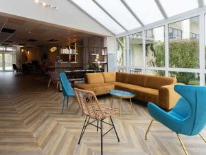 a living room with a couch and chairs at ibis Styles Chinon in Chinon