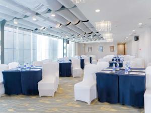 a conference room with blue tables and white chairs at Novotel Guiyang Downtown in Guiyang