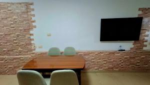 a table with two chairs and a television on a wall at Sweet Home in Pogradec