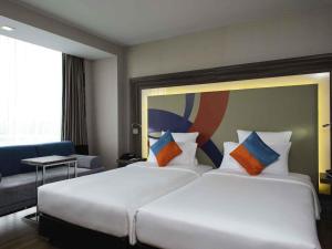 a hotel room with two beds and a couch at Novotel Bangkok IMPACT in Nonthaburi +173 photos