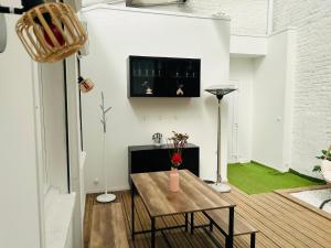 a living room with a table and a tv at Green Love Suite in Tourcoing