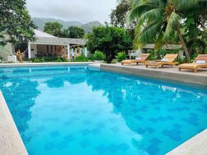 a swimming pool with chairs and a house at Senda Beach House Tayrona in Santa Marta +17 photos