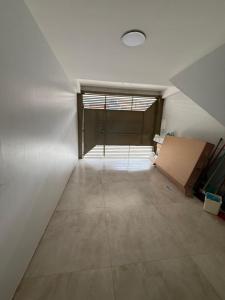 an attic room with a large window and a room with a door at Triplex Belém in Belém