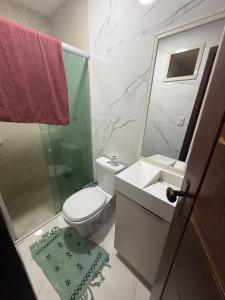 a bathroom with a toilet and a sink and a shower at Triplex Belém in Belém