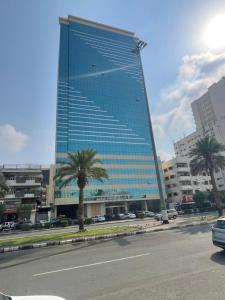 a tall building with a palm tree in front of it at الخلفاء الماسى in Makkah
