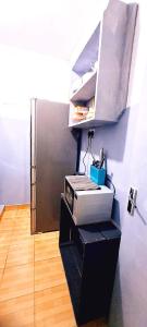キタレにあるJoy's One Bedroom Apartmentの冷蔵庫とプリンター付きの机がある部屋