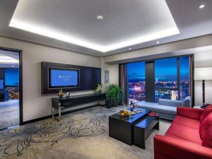 a living room with a red couch and a tv at Pullman Guiyang in Guiyang