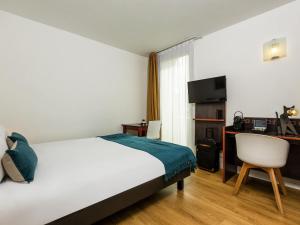 a hotel room with a bed and a desk at Aparthotel Adagio Access Paris Porte De Charenton in Charenton-le-Pont