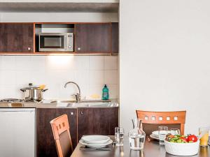 a kitchen with a table and a microwave at Aparthotel Adagio Access Paris Porte De Charenton in Charenton-le-Pont