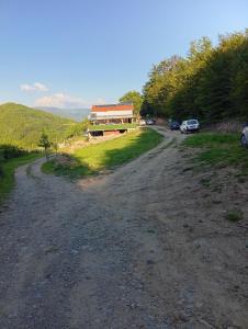 a dirt road next to a building with cars parked at Vila Kostadinovic in Pirot