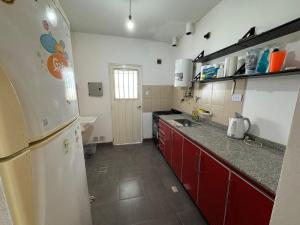 a kitchen with a white refrigerator and red cabinets at El Recodo in La Rioja