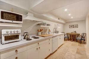 Una cocina con gabinetes blancos y un horno de estufa. en Elsewhere on Madison Square Garden, en Savannah