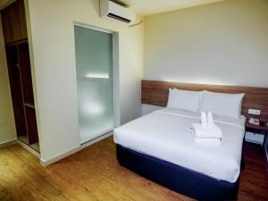 a bedroom with a large white bed in a room at Rooms By Rocana in Kuantan