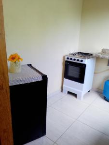 a kitchen with a black and white stove top oven at Casa Caiçara Paraty in Paraty