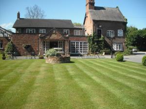 a large house with a large lawn in front of it at Wincham Hall Hotel in Northwich