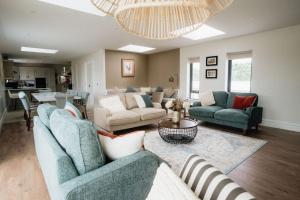 a living room with two blue couches and a table at Balleeghan House in Malin
