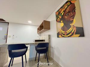 a kitchen with a painting of a woman on the wall at Imperial Nobile in Tambaú