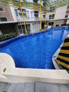 a large blue swimming pool in a building at Pioneer Woodlands Tower 5 Unit 33-Q in Manila