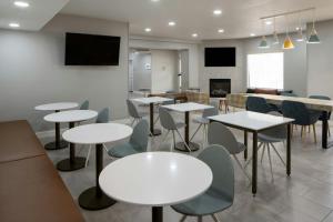 Un comedor con mesas y sillas blancas. en TownePlace Suites by Marriott Texarkana, en Texarkana