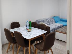 a dining room with a table and chairs with bottles on it at Sara apart in Pojate +19 photos