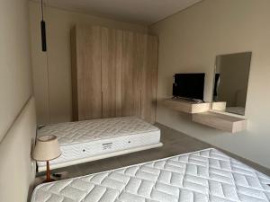 a bedroom with two beds and a television in it at Mozaik Condotel in Cairo