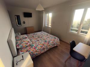 a bedroom with a bed and a desk and a chair at Notre Dame d'Orgemont - Bleu Nuit 4 in Argenteuil