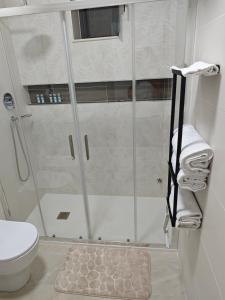 a bathroom with a shower with a toilet and a rug at B&B Delle Rose in Orta Nova