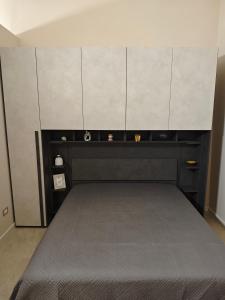 a bedroom with a bed with cabinets above it at B&B Delle Rose in Orta Nova