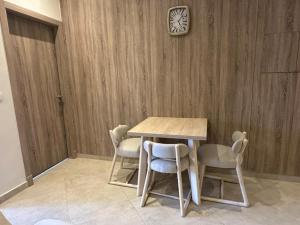 a table with chairs and a clock on a wall at Mozaik Condotel in Cairo +10 photos
