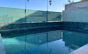 a swimming pool with a fence and some water at Riad Diamond Of Marrakech & Spa in Marrakech