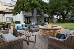 a patio with a fire pit with chairs and tables at Courtyard Dallas Las Colinas in Irving