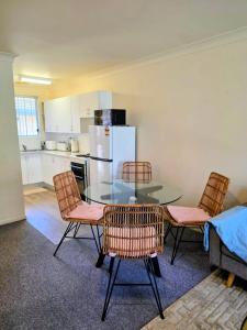 a kitchen with a glass table and chairs in a room at Tuncurry 2BR Walk to Lake in Tuncurry