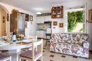 a kitchen and living room with a couch and a table at Appartamento Bouganville in Porto Alabe +27 photos