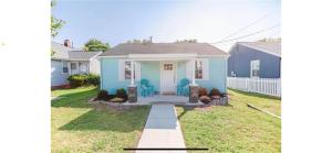 a blue house with a white door in a yard at Midtermlongterm Buckroe Beach Bungalow Ev Chrg in Hampton