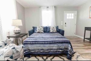 a bedroom with a large bed with a blue blanket at Midtermlongterm Buckroe Beach Bungalow Ev Chrg in Hampton