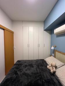 a teddy bear sitting on a bed in a bedroom at Complet apartment with air conditioning in Belém
