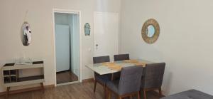 una sala da pranzo con tavolo, sedie e uno specchio di Dois quartos espaçoso a Vitória Altre 18 foto