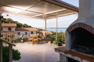 a patio with an outdoor fireplace and a table and chairs at Appartamento Bouganville in Porto Alabe