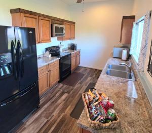 a kitchen with a black refrigerator and a sink at Immaculate Home w/ Mtn and River Views! in East Wenatchee +20 photos