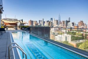 a swimming pool on top of a building with a city skyline at Hotel Indigo Lower East Side New York by IHG in New York