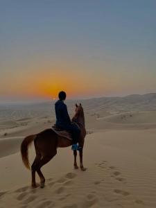 una persona montando un caballo en el desierto en farah desert camp, en Oulad Driss