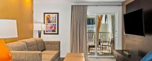 a living room with a couch and a chair and a television at Worldmark Tropicana Avenue in Las Vegas