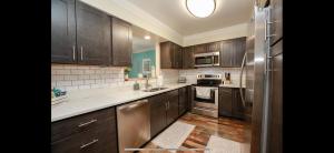 a kitchen with wooden cabinets and stainless steel appliances at MidLongTerm Rntal Comfy Home Away Near VA Beach in Virginia Beach