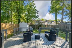 a deck with two couches and a fence at MidLongTerm Rntal Comfy Home Away Near VA Beach in Virginia Beach