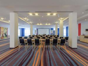 a conference room with a long table and chairs at ibis Styles Leipzig in Radefeld